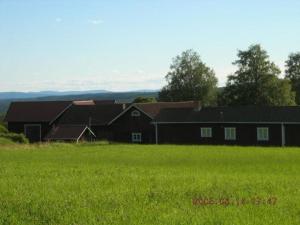 um grande celeiro preto num campo de relva verde em Landestypisches Blockhaus mit kleiner Eingangsveranda 
