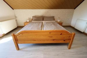 a large wooden bed in a room with two tables at Ferienhaus Panoramablick in Piesau