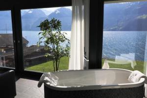 bañera en una habitación con ventana grande en Ferienvilla am See 3 für 2-4 Personen, en Sisikon