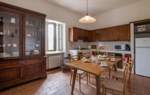 cocina con mesa de madera con sillas y nevera en Cozy Home In Rieti With Kitchen en Rieti