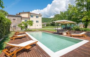 una piscina con sillas y sombrilla en Cozy Home In Rieti With Kitchen en Rieti
