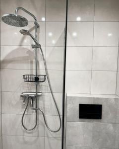 a shower with a shower head in a bathroom at Domek Pierwiosnek Ustroń in Ustroń