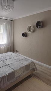a bedroom with a bed and shelves on the wall at BOGINE Apartament in Ventspils