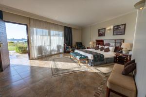 Jolie Ville Hotel & Spa Kings Island Luxor في الأقصر: غرفة نوم كبيرة مع سرير وغرفة معيشة