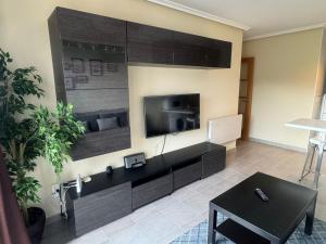 a living room with a flat screen tv on a wall at Costa SPA Ático de lujo - Playa de las Catedrales in San Miguel de Reinante