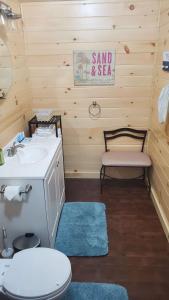 a bathroom with a sink and a toilet and a bench at Lighthouse Cabins Maine in Bass Harbor