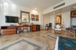 ein großes Wohnzimmer mit einem Schreibtisch und einem Spiegel in der Unterkunft Jolie Ville Hotel & Spa Kings Island Luxor in Luxor