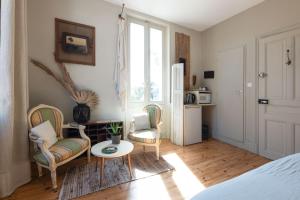 ein Wohnzimmer mit 2 Stühlen und einem Tisch in der Unterkunft Demeure Urbaine in Romans-sur-Isère