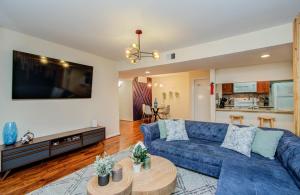 a living room with a blue couch and a table at 3 Bedrooms Spacious Central Condo w Pool in Houston