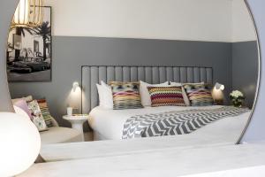 a bedroom with a large bed with a mirror at Hotel & Plage Croisette Beach Cannes Mgallery in Cannes