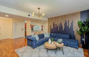 a living room with a blue couch and a table at 3 Bedrooms Spacious Central Condo w Pool in Houston