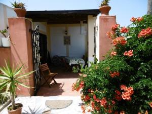 una casa con un porche con flores y un banco en Landhaus Casa Nonna im Olivenhain, en Balestrate