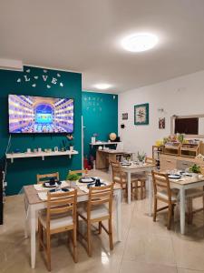 une salle à manger avec des tables, des chaises et une télévision dans l'établissement B&B VENTO DEL SUD, à Palerme