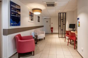 una sala de espera en un hospital con sillas y una mesa en ACE Hôtel Bordeaux Carbon Blanc en Carbon-Blanc