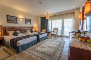 盧克索的住宿－Jolie Ville Hotel & Spa Kings Island Luxor，酒店客房带两张床和一张桌子以及椅子。