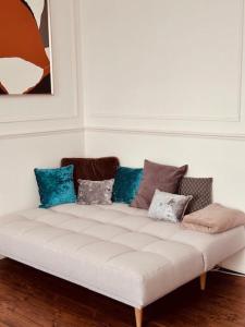 um sofá branco com almofadas num quarto em Stylish 2-Bed Flat in London em Londres