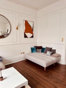 uma sala de estar com um sofá branco e um espelho em Stylish 2-Bed Flat in London em Londres