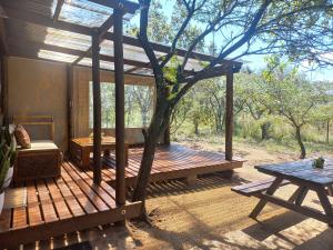 a wooden deck with a table and a picnic table at Five Pebbles on Piece of Africa in Cullinan
