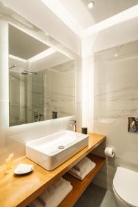 Danae Hotel في ايجينا تاون: حمام أبيض مع حوض ومرآة