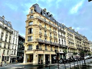 un grand bâtiment avec un panneau à l'avant dans l'établissement Hotel Viator - Gare de Lyon, à Paris