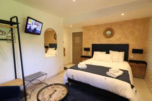 Un dormitorio con una cama grande con un reloj en la pared. en Au Bonheur d'Angeline, en Castelnaud La Chapelle