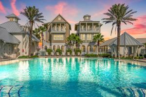 a mansion with a large pool in front of it at Green Turtle Cottage in Port Aransas