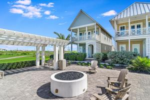 a house with a patio with chairs and a fountain at Green Turtle Cottage in Port Aransas