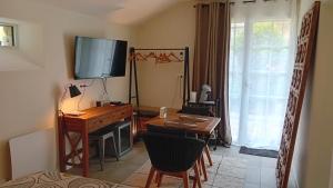 uma sala de estar com uma secretária, uma televisão e uma mesa em Le Clos de l'Aiguillon 