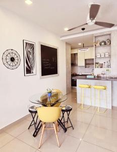 een keuken en eetkamer met een glazen tafel en stoelen bij Comfy Abode at transport hub, TBS in Kuala Lumpur