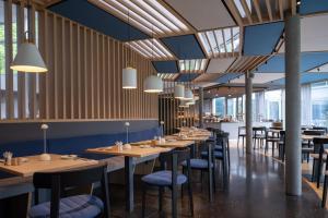 une salle à manger avec des tables et des chaises en bois dans l'établissement Val Blu Sport | Hotel | SPA, à Bludenz