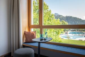 einen Tisch in einem Zimmer mit einem großen Fenster in der Unterkunft Val Blu Sport | Hotel | SPA in Bludenz