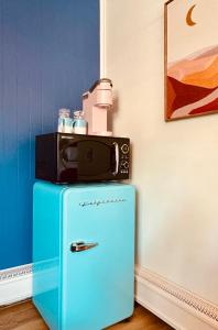 a blue refrigerator with a microwave on top of it at The Sierra Motel in Traverse City
