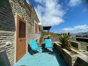 a patio with two chairs and a door at Casa Capo Falcone - Terraced house with wonderful sea view - in Stintino