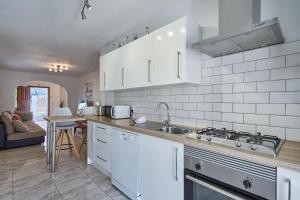 a kitchen with white cabinets and a sink at Villa Fleming in Santanyi