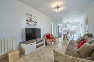 a living room with a couch and a flat screen tv at Villa Fleming in Santanyi