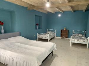 a bedroom with two beds and a blue wall at hotel pillows in Martvili