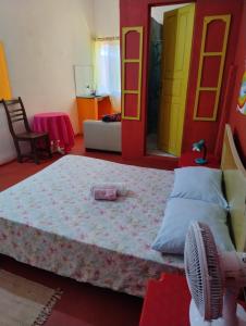 um quarto com uma cama grande e uma ventoinha em Perto Do Aeroporto De Salvador - Dona Pitanga Hostel em Lauro de Freitas