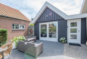 a patio with a couch and chairs on a house at De Grote Stern in Groet