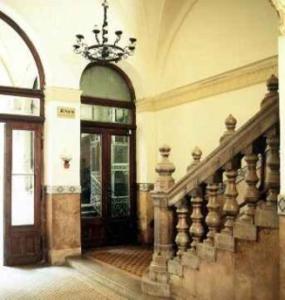 a large room with a staircase and a chandelier at Imre Guest House in Budapest
