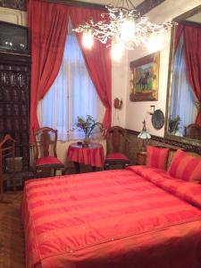 a bedroom with a red bed and a table with chairs at Imre Guest House in Budapest