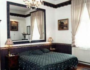 Imre Guest House في بودابست: غرفة نوم بسرير ومرآة كبيرة