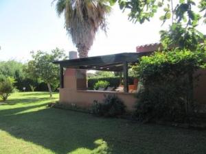 ein Gebäude in einem Hof mit einer Palme in der Unterkunft Ferienhaus für 10 Personen ca 68 qm in Costa Rei, Sardinien Sarrabus Gerrei in Costa Rei