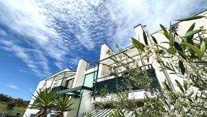 a white building with palm trees in front of it at SE095 - Marzocca, trilocale comodo al mare e ai servizi in Marzocca di Senigallia