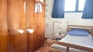 a bedroom with a wooden cabinet and a bed at SE095 - Marzocca, trilocale comodo al mare e ai servizi in Marzocca di Senigallia