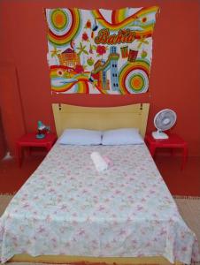um quarto com uma cama com uma cabeceira e duas mesas em Perto Do Aeroporto De Salvador - Dona Pitanga Hostel em Lauro de Freitas