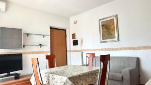 a dining room with a table and a television at SE095 - Marzocca, trilocale comodo al mare e ai servizi in Marzocca di Senigallia