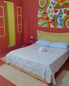 een slaapkamer met een bed met een knuffeldier erop bij Perto Do Aeroporto De Salvador - Dona Pitanga Hostel in Lauro de Freitas