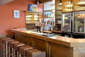 un bar con una fila de taburetes en un restaurante en La Couronne en Welkenraedt