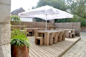 a patio with a table and an umbrella at La Couronne in Welkenraedt