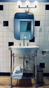 een badkamer met een wastafel met een spiegel en handdoeken bij The Sierra Motel in Traverse City